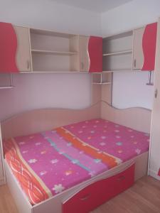 un letto a castello per bambini con un letto rosa e viola di Apartament a Curtea de Argeş
