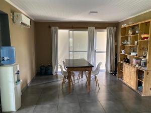 een keuken met een tafel, stoelen en een koelkast bij Las estrellas in Las Tapias