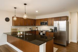 Spacious Downtown Sq Stadium, Casino, R&R HoF! في كليفلاند: مطبخ مع خزائن خشبية وثلاجة من الفولاذ المقاوم للصدأ