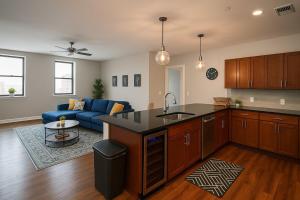 Spacious Downtown Sq Stadium, Casino, R&R HoF! في كليفلاند: مطبخ وغرفة معيشة مع أريكة زرقاء