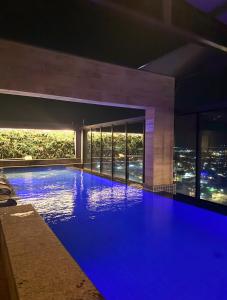 a swimming pool at night with a city view at Flat 1807 - Sunset Experience Alto Padrão in Dourados