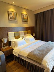 Un dormitorio con una cama grande con sábanas y almohadas blancas. en Lux Apartment in Dreamland Oasis, en Chakvi 6 fotos más