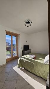 une chambre avec un lit et une télévision dans l'établissement Appartamento da Nonna Anna, à Montagna in Valtellina