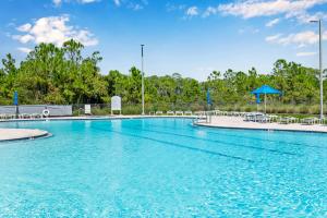 una piscina in un resort con sedie e ombrelloni di Serenity on Sable a Perdido Key