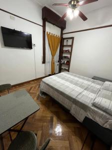 Un dormitorio con una cama y un ventilador de techo. en Obelisco Buenos Aires, en Buenos Aires