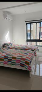 een bed met een kleurrijk dekbed in een slaapkamer bij Ponta do Sol "A Boa Vida" in Ponta do Sol