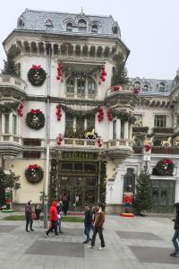people walking in front of a building with christmas decorations at Grand Apartments Centre of Craiova in Craiova