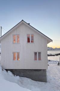een wit huis met een hond ervoor bij Arctic Nest in Nyksund