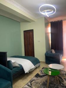 une chambre avec un lit, un canapé et une table dans l'établissement Hella home, à Kampala 1 autre photo