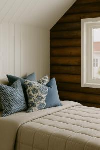 een bed met kussens in een kamer bij Arctic Nest in Nyksund