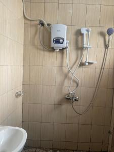La salle de bains est pourvue d'une douche murale et d'un sèche-mains. dans l'établissement Hella home, à Kampala