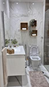 a white bathroom with a sink and a toilet at kriola Breeze in Praia