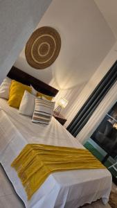 a bedroom with a large white bed with yellow pillows at kriola Breeze in Praia +11 photos