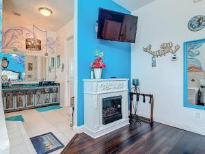 a living room with a fireplace and a tv on the wall at Inn on the Avenue in New Smyrna Beach +59 photos