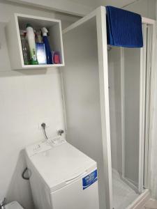 een kleine badkamer met een toilet en een plank boven een wasmachine bij Miniloft scala blu in Milaan +24 foto's