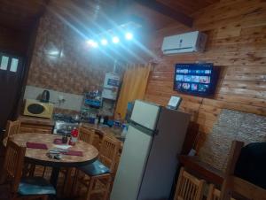 une cuisine avec un réfrigérateur et une table à l'intérieur dans l'établissement Cabaña el amanecer, à Dolores