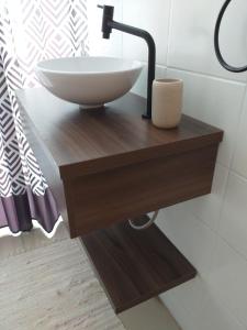 a sink on a wooden table in a bathroom at Sambaqui - Casa de Hóspedes Kitinet in Florianópolis