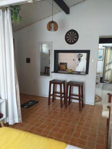 a living room with two stools and a mirror at Sambaqui - Casa de Hóspedes Kitinet in Florianópolis