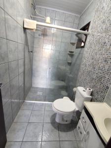 a bathroom with a shower and a toilet and a sink at Apto com terraço coberto in Arroio do Sal
