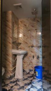 een badkamer met een wastafel en een houten muur bij Banani Luxury Guest House in Dhaka