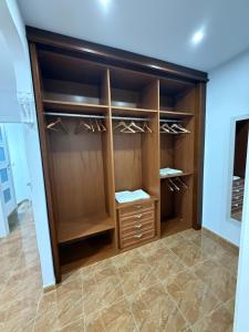 Un vestidor con gabinetes de madera y piso de baldosas. en ALOJAMIENTO Rural AVD SIERRA MÁGINA, en Carchelejo 18 fotos más