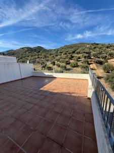 Un patio con una valla y montañas al fondo. en ALOJAMIENTO Rural AVD SIERRA MÁGINA, en Carchelejo