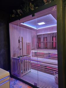 T2 Cosy spacieux Balneo Sauna Parking Noel في ستراسبورغ: غرفة زجاجية كبيرة بها أحزمة حمراء