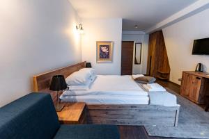 a bedroom with two beds and a couch at Maar Hotel Brezovice in Prevallë