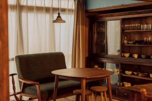 a room with a table and a chair and a table and a window at 隠れ古宿 おくゆかし in Beppu