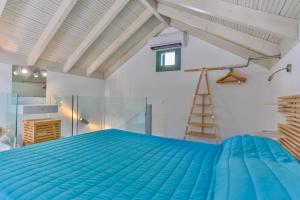 a bedroom with a blue bed and a ladder at Annika Deluxe Apartments in Symi +26 photos