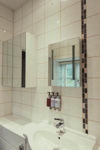 The Falcon Inn في Saint Mawgan: حمام مع حوض أبيض ومرآة +29 صورة