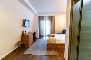 a hotel room with a bed and a desk at Maar Hotel Brezovice in Prevallë +20 photos