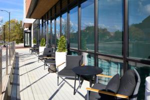 balcón con sillas, mesas y ventanas en AC Hotel by Marriott Auburn, en Auburn