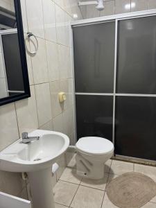 ein Badezimmer mit Toilette, Waschbecken und Dusche in der Unterkunft Apart CENTRO in Tubarão