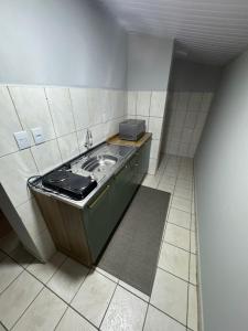 eine kleine Küche mit einem Waschbecken in einem Zimmer in der Unterkunft Apart CENTRO in Tubarão
