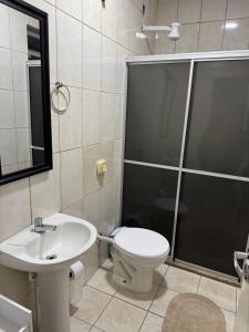 a bathroom with a toilet and a shower and a sink at Apart 102 CENTRO in Tubarão