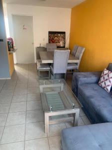 a living room with a couch and a table at Casa en fraccionamiento en Ahuatepec con alberca, cancha y cerca de Tepoztlán  +22 photos