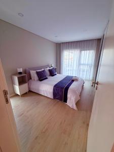 una camera da letto con un letto grande e una finestra di JolikaS House Heated Pool and EV point a Fernão Ferro