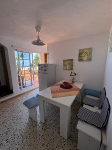 a kitchen with a white table and chairs and a refrigerator at Finca Rosa in Güimar