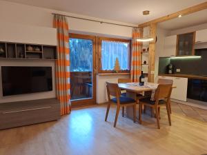 a kitchen and dining room with a table and chairs at Apartments Insam in Santa Cristina in Val Gardena
