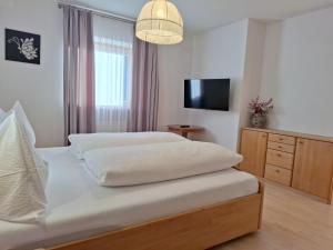 a bedroom with two beds and a flat screen tv at Apartments Insam in Santa Cristina in Val Gardena +32 photos
