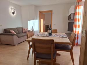 a living room with a table with a bottle of wine on it at Apartments Insam in Santa Cristina in Val Gardena