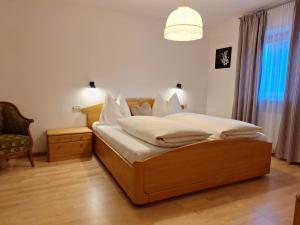 a bedroom with a bed and a chair at Apartments Insam in Santa Cristina in Val Gardena