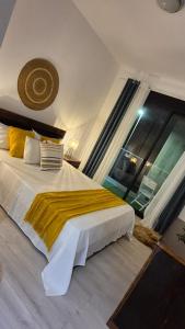 a bedroom with a large bed with a yellow blanket at kriola Breeze in Praia
