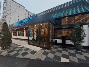 ein Geschäft mit Schachbrettmuster vor einem Gebäude in der Unterkunft TURQUOISE Hostel in Bukarest