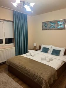 a bedroom with a large bed with a blue curtain at Apartament doua camere in Baia Mare