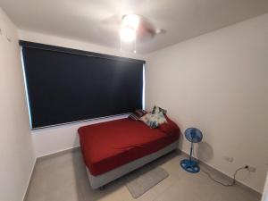 a bedroom with a red bed with a large window at Río Hato in El Chirú