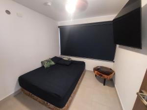 a small bedroom with a bed and a large screen at Río Hato in El Chirú