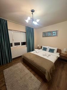 a bedroom with a large bed with green curtains at Apartament doua camere in Baia Mare +2 photos