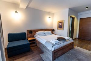 a bedroom with a bed and a chair at Maar Hotel Brezovice in Prevallë